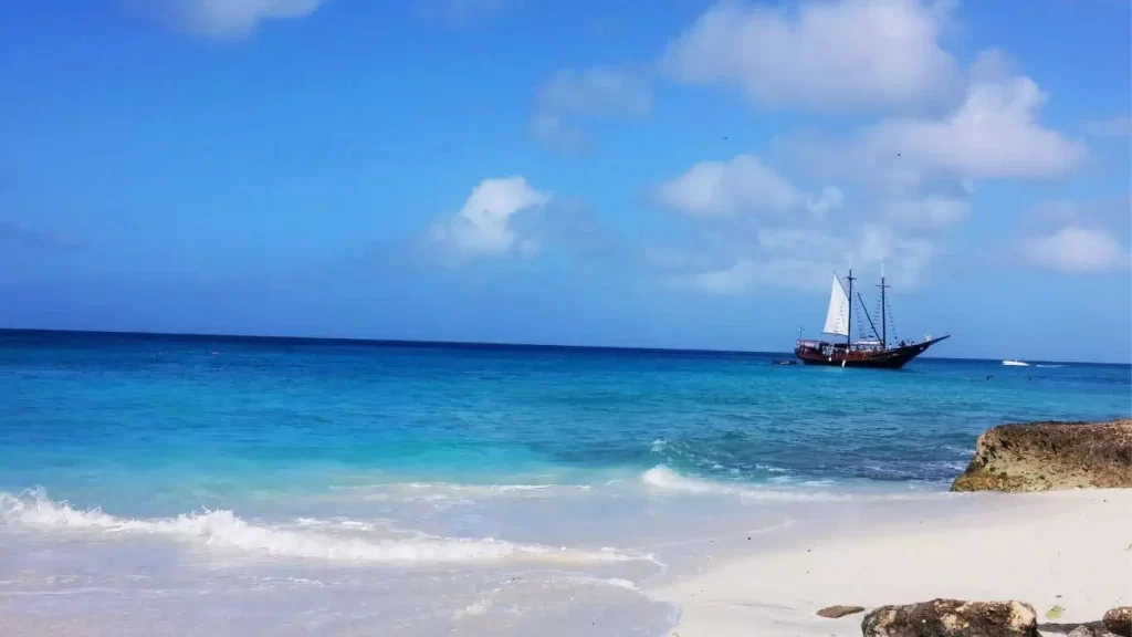 Aruba beach with sailboat on the horizon