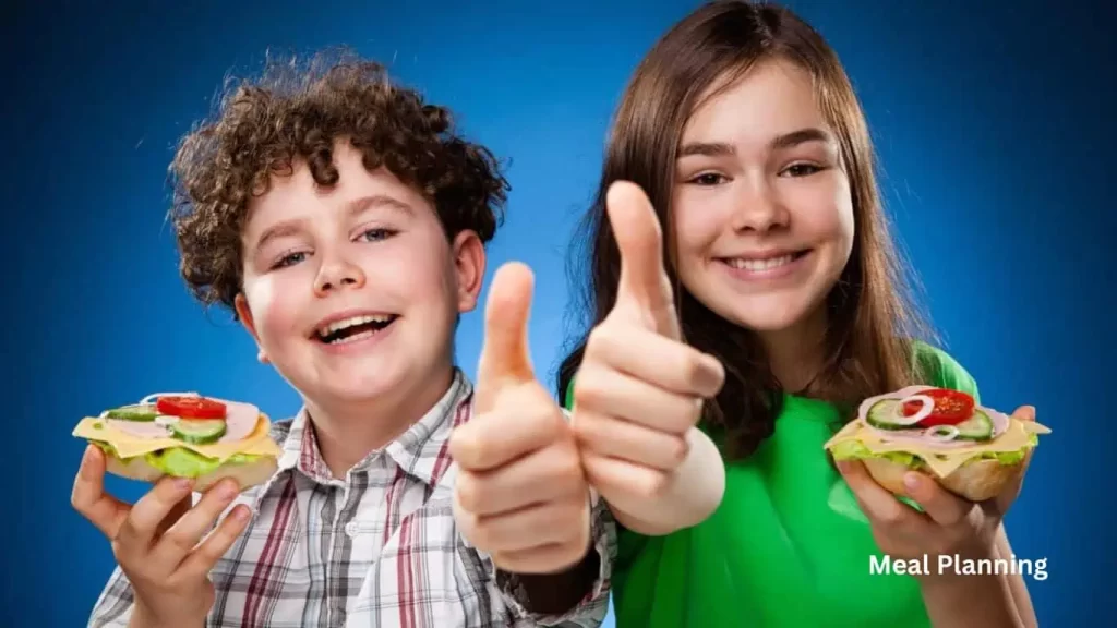 2 kids enjoying a sandwich