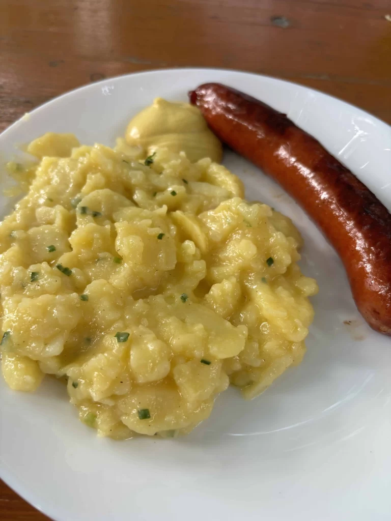 A plate with a traditional sausage and potato salad in Christmas Market in Munich