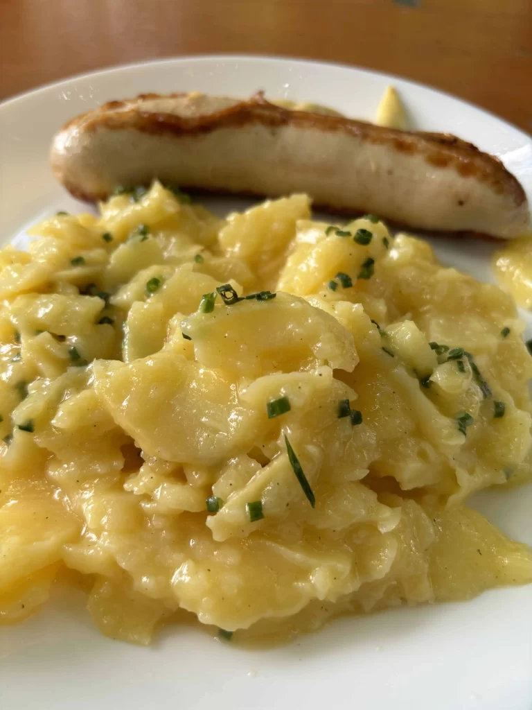 A plate with a traditional sausage and potato salad in Christmas Market in Munich